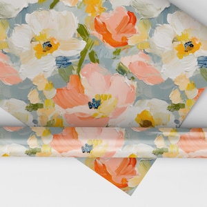 May include: A roll of wrapping paper with a floral pattern. The paper features a light blue background with pink, white, and yellow flowers. The flowers are painted in a loose, abstract style.