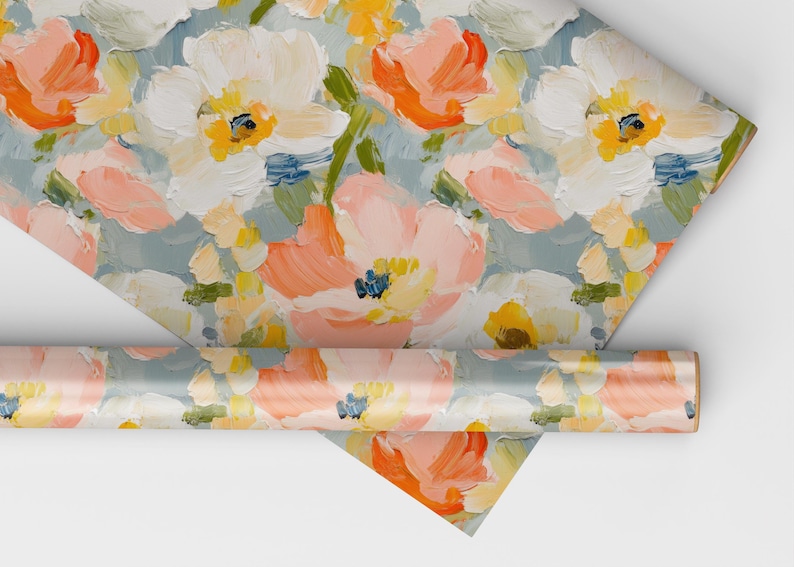 May include: A roll of wrapping paper with a floral pattern. The paper features a light blue background with pink, white, and yellow flowers. The flowers are painted in a loose, abstract style.