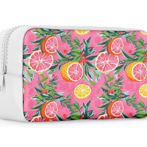 May include: White zippered pouch with a pink background and a repeating pattern of pink grapefruit slices, green leaves, and red berries.
