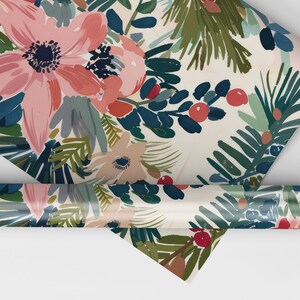 May include: A roll of wrapping paper with a floral pattern featuring pink, red, and blue flowers, green leaves, and red berries on a white background.