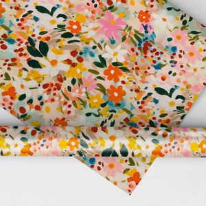 Pu&ograve; includere: Un rotolo di carta da regalo con motivo floreale su sfondo bianco e fiori colorati in tonalit&agrave; di rosa, arancio, giallo, blu e verde.