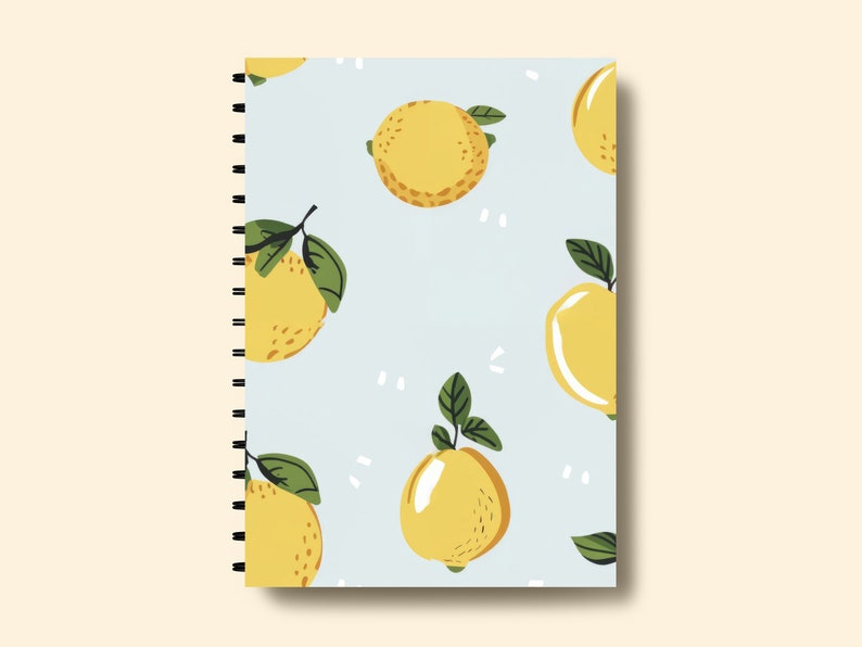 Puede incluir: Una libreta azul con encuadernaci&oacute;n en espiral presenta un patr&oacute;n repetitivo de limones amarillos con hojas verdes sobre un fondo azul claro.