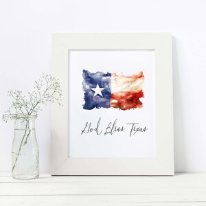 Może przedstawiać: Biała oprawa z nadrukiem akwareli przedstawiającej flagę Teksasu i tekstem "God Bless Texas".