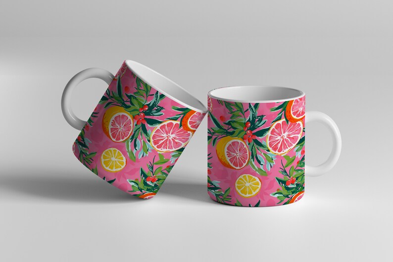 May include: Two white ceramic mugs with a pink background and a pattern of lemons, grapefruits, and green leaves.