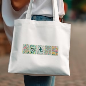 White tote bag with five floral illustrated playing cards.