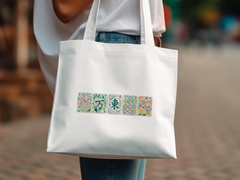 White tote bag with five floral illustrated playing cards.