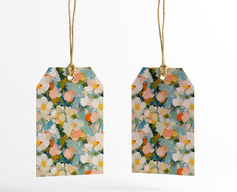 May include: Two gift tags with a floral pattern. The tags are white with blue, pink, yellow, and orange flowers. The tags are tied with twine.