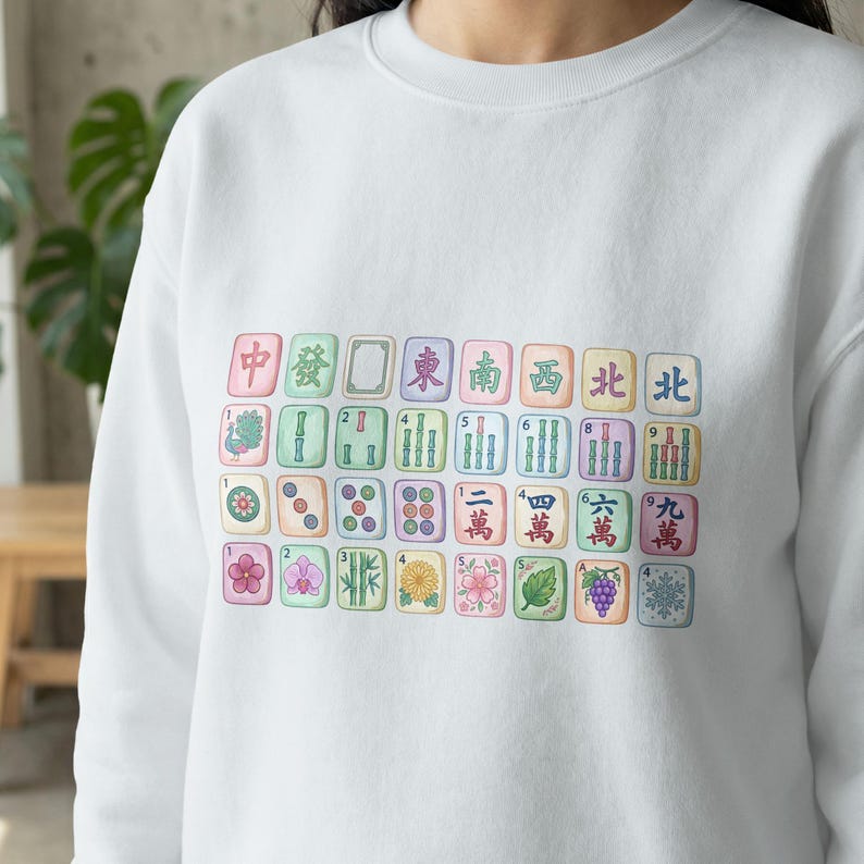 Mahjong tiles printed on a white sweatshirt, featuring Chinese characters and numbers.
