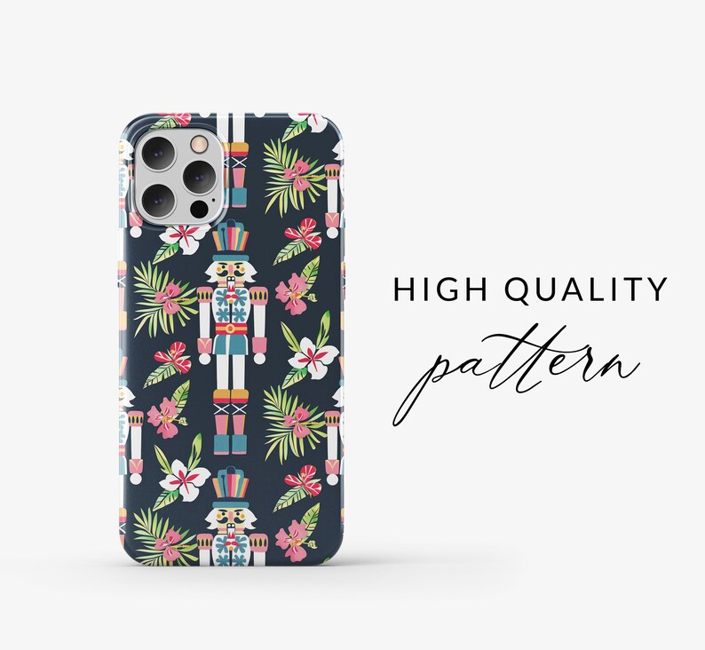 Pu&ograve; includere: Una custodia per telefono con un motivo ripetitivo di schiaccianoci e fiori tropicali su uno sfondo blu scuro. Gli schiaccianoci indossano cappelli colorati e hanno un design fantasioso. I fiori sono rosa e bianchi con foglie verdi.