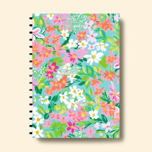 K&ouml;nnte beinhalten: Ein spiralgebundenes Notizbuch mit einem Blumenmuster auf dem Einband. Der Einband zeigt eine Vielzahl von rosa, orange, wei&szlig;en und gr&uuml;nen Blumen auf einem hellblauen Hintergrund.