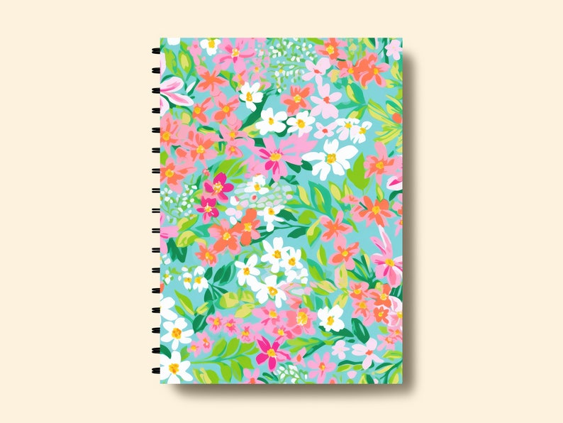 K&ouml;nnte beinhalten: Ein spiralgebundenes Notizbuch mit einem Blumenmuster auf dem Einband. Der Einband zeigt eine Vielzahl von rosa, orange, wei&szlig;en und gr&uuml;nen Blumen auf einem hellblauen Hintergrund.