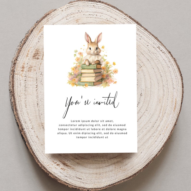 Op de afbeelding: Een witte kaart met een aquarel-illustratie van een konijn dat op een stapel boeken zit, omringd door bloemen. De tekst "You're invited" is geschreven in zwarte cursieve letters. De kaart heeft een witte achtergrond en de tekst "Lorem ipsum dolor sit amet, consectetur adipiscing elit, sed do eiusmod tempor incididunt ut labore et dolore magna aliqua. Ut enim dipiscing elit, sed do eiusmod tempor incididunt ut" is in zwart geschreven.
