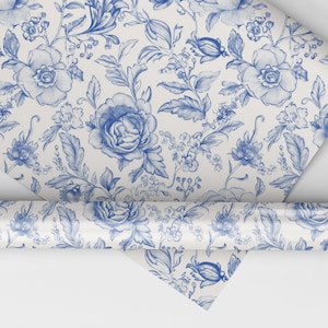 May include: A roll of blue and white floral wrapping paper with a repeating pattern of blue flowers and leaves on a white background.
