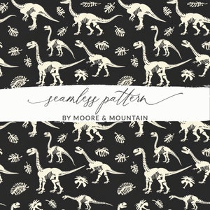 May include: A seamless pattern featuring white dinosaur skeletons on a black background. The pattern also includes white leaf shapes. The text "seamless pattern" and "BY MOORE & MOUNTAIN" is included in the image.