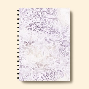 May include: A spiral bound notebook with a white lace pattern on a purple background.
