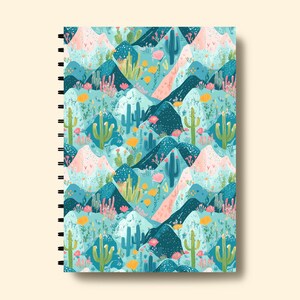 May include: A spiral bound notebook with a colorful pattern of cacti and mountains in shades of blue, green, pink, and yellow.