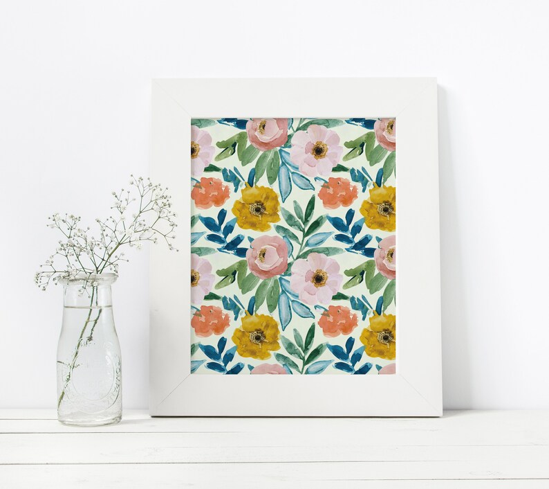 May include: A white frame with a floral print featuring pink, yellow, and orange flowers on a light green background.