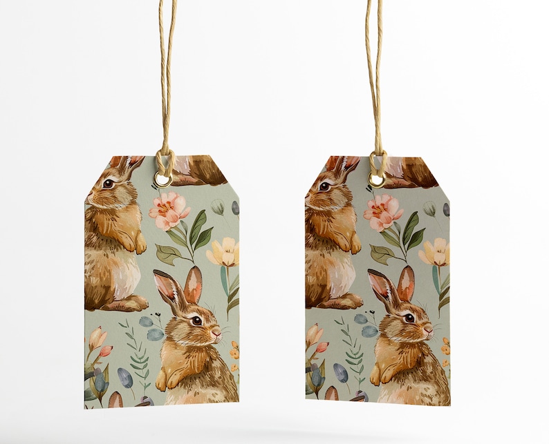 May include: Two green gift tags with a repeating pattern of brown rabbits and pink, yellow, and white flowers. The tags are tied with twine.