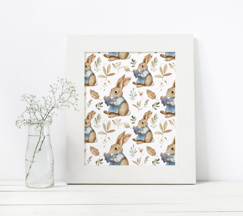 May include: A white framed print with a repeating pattern of brown rabbits wearing blue shirts and holding books. The rabbits are surrounded by brown leaves and green foliage.