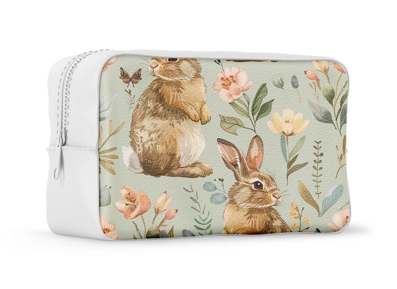 May include: White zippered pouch with a floral pattern featuring brown rabbits and butterflies on a light green background.