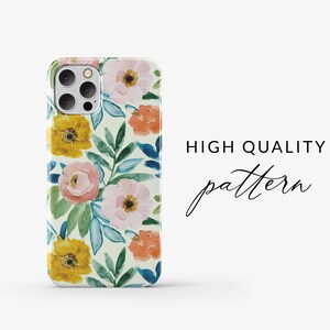 May include: A phone case with a floral pattern. The case features a white background with pink, yellow, and orange flowers, and green and blue leaves. The case has a camera cutout and a "HIGH QUALITY pattern" text.