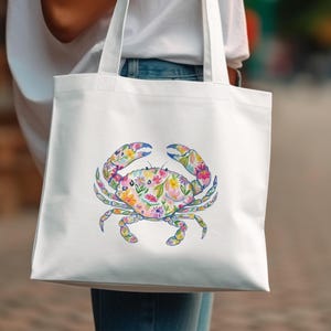 White tote bag with a colorful floral crab design.