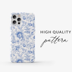 May include: A white iPhone case with a blue floral pattern. The case has a camera cutout and a raised lip around the edges. The text "HIGH QUALITY pattern" is visible in the background.