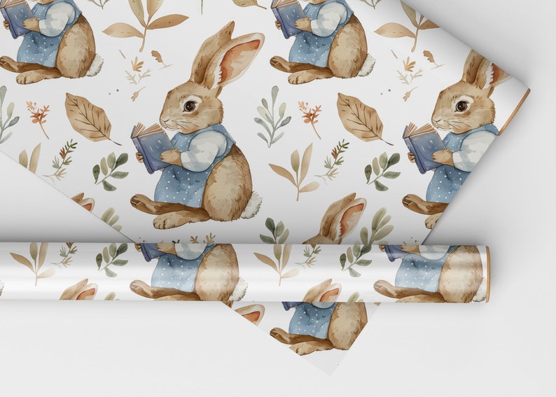 May include: A white wrapping paper with a repeating pattern of brown rabbits holding blue books, surrounded by green and brown leaves.
