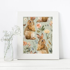 May include: A white framed print with a repeating pattern of brown rabbits and pastel flowers on a light green background.