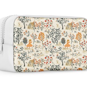 Puede incluir: Bolsa blanca con cremallera con un fondo crema y un patr&oacute;n repetido de peque&ntilde;as casas, &aacute;rboles y personas. El patr&oacute;n est&aacute; en tonos de naranja, rojo, verde y azul.