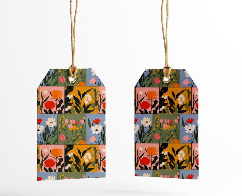 May include: Two floral gift tags with a patchwork design of colourful flowers and leaves on a blue, green, pink, and yellow background. The tags are attached to twine.