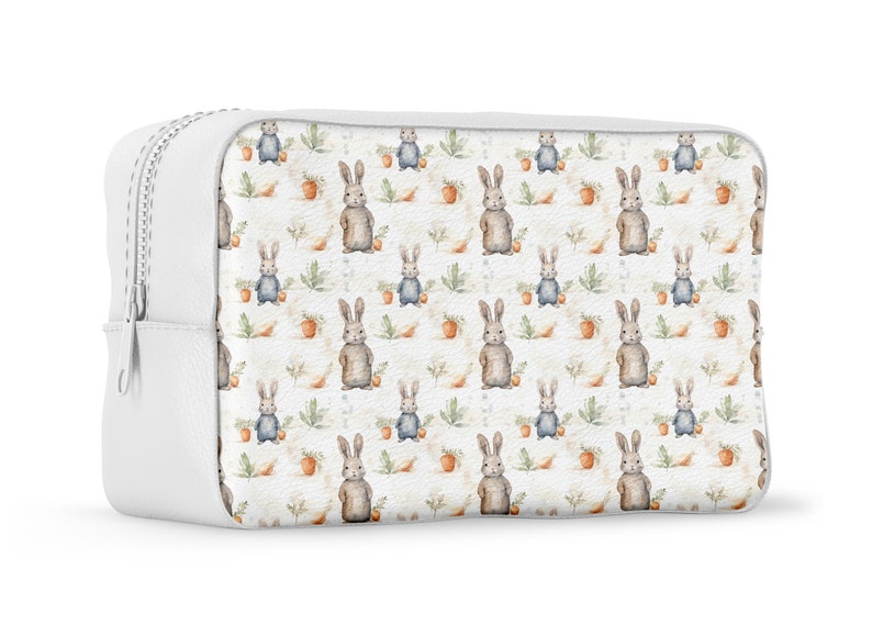 May include: White zippered cosmetic bag with a repeating pattern of watercolor bunnies and carrots on a white background.