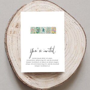 Invitation card with floral tiles and cursive text on wood slice.