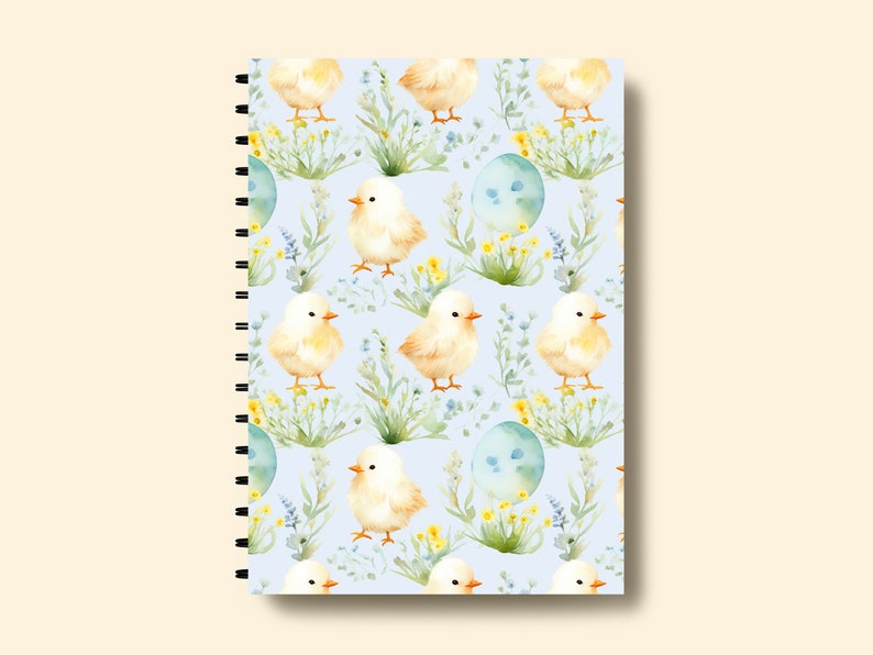 May include: A spiral bound notebook with a light blue cover featuring a repeating pattern of yellow chicks, blue eggs, and green foliage.