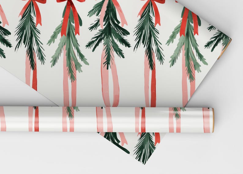 K&ouml;nnte beinhalten: Wei&szlig;es Geschenkpapier mit einem sich wiederholenden Muster aus gr&uuml;nen Kiefern&auml;sten und roten und rosafarbenen B&auml;ndern. Das Papier ist aufgerollt und das Ende ist sichtbar.