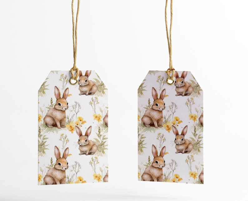 May include: Two white gift tags with brown string attached. The tags feature a repeating pattern of brown bunnies and yellow flowers on a white background.