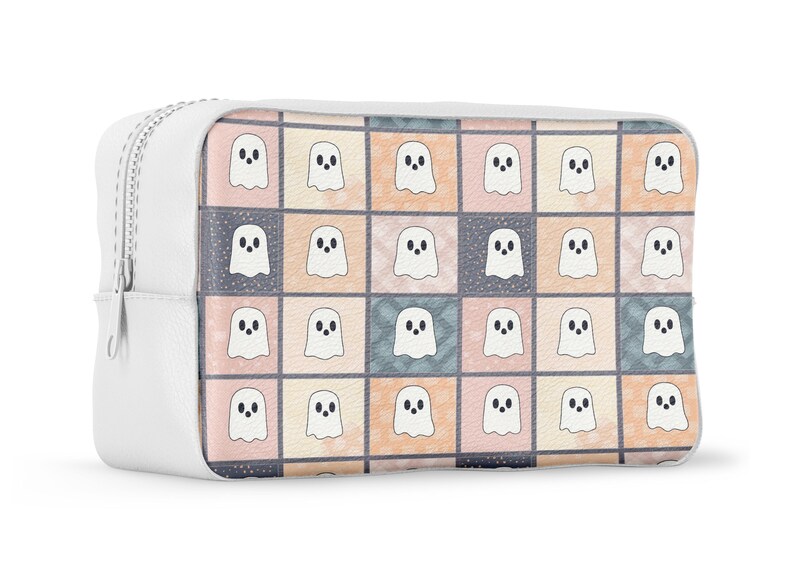 May include: White cosmetic bag with a zip closure. The bag has a colourful pattern of ghost illustrations on the front. The ghosts are white with black eyes and mouths, set against a patchwork of pastel squares.