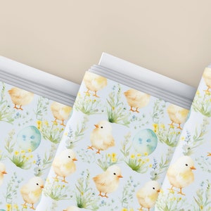 May include: A stack of blue and white patterned paper with a watercolor design of yellow chicks and flowers. The paper is perfect for wrapping gifts or creating crafts.