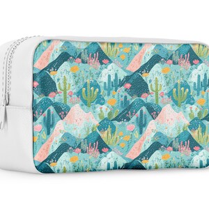 May include: White zippered pouch with a colorful pattern of cacti and mountains on a blue background.