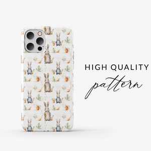 May include: A white iPhone case with a repeating pattern of brown rabbits holding carrots and blue rabbits with green leaves. The text "HIGH QUALITY pattern" is visible in the background.