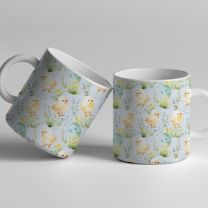 May include: Two white ceramic mugs with a blue background and a repeating pattern of yellow chicks, green grass, and blue eggs.