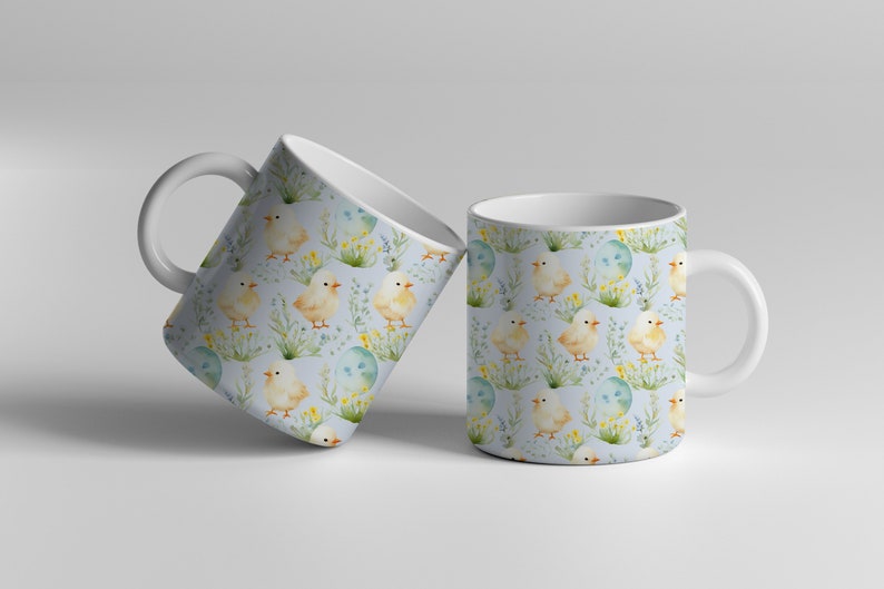 May include: Two white ceramic mugs with a blue background and a repeating pattern of yellow chicks, green grass, and blue eggs.