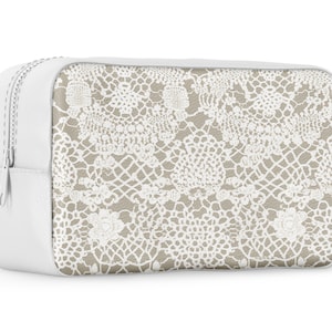 May include: White zippered pouch with a beige background and a white lace pattern.