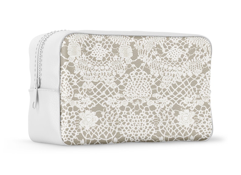 May include: White zippered pouch with a beige background and a white lace pattern.