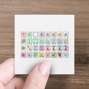 Mahjong tiles with Chinese characters and numbers displayed on a sticker.
