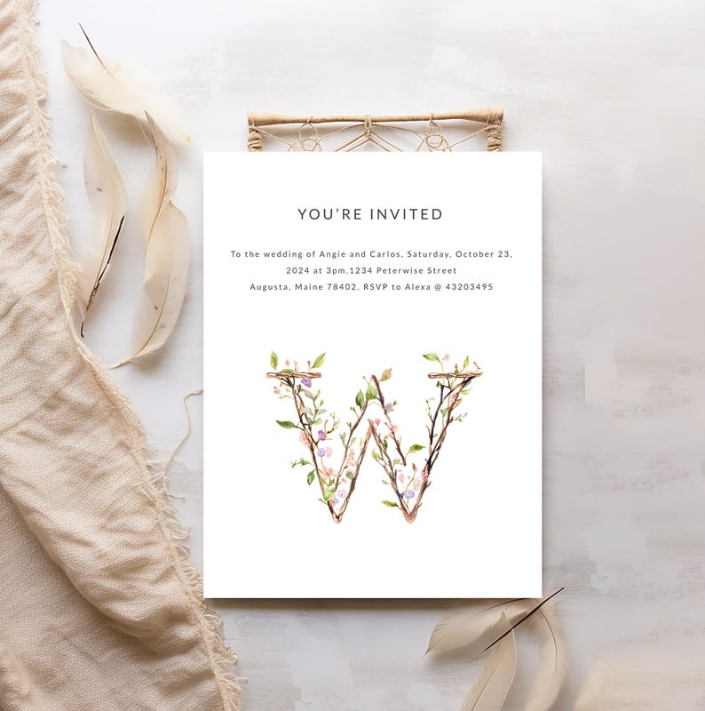 May include: Wedding invitation with a floral letter W design. The invitation reads "You're Invited" to the wedding of Angie and Carlos on Saturday, October 23, 2024 at 3pm. 1234 Peterwise Street, Augusta, Maine 78402. RSVP to Alexa @ 43203495.