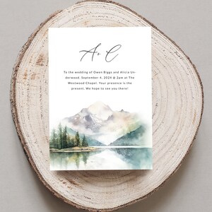 May include: A wedding invitation with a watercolor illustration of a mountain range and a lake. The text reads "A + L" and "To the wedding of Owen Biggs and Alicia Underwood. September 4, 2024 @ 2pm at The Westwood Chapel. Your presence is the present. We hope to see you there!"