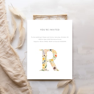 May include: A wedding invitation with a floral letter R. The invitation reads "You're Invited" to the wedding of Angie and Carlos on Saturday, October 23, 2024 at 3pm. 1234 Peterwise Street, Augusta, Maine 78402. RSVP to Alexa @ 43203495.