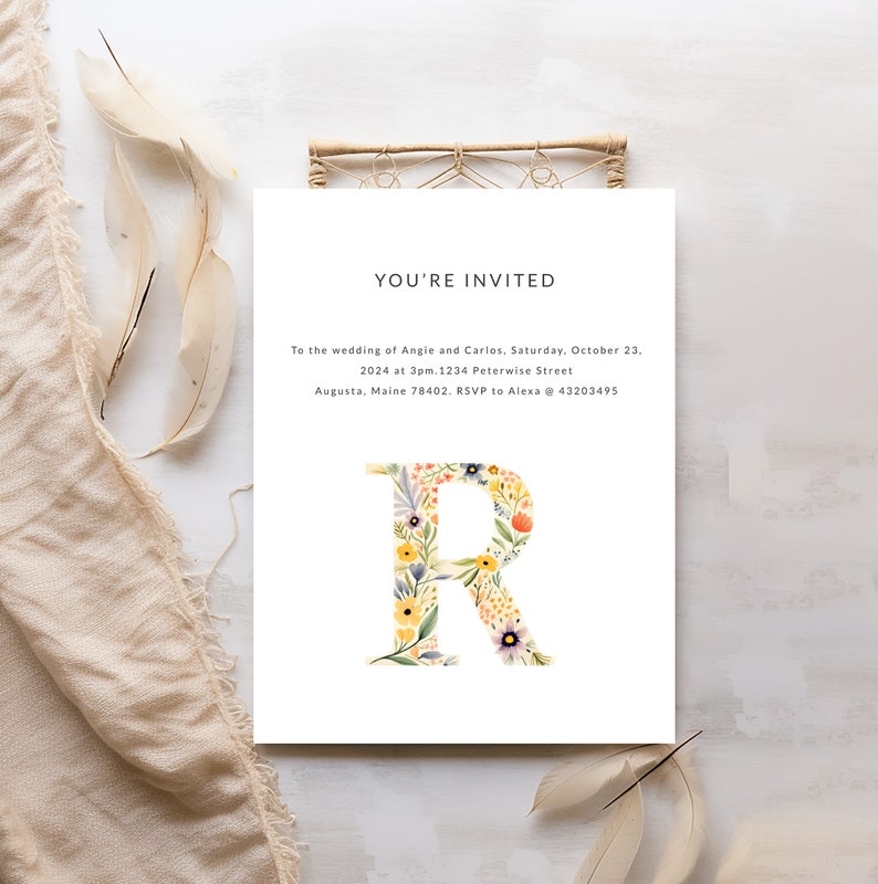 May include: A wedding invitation with a floral letter R. The invitation reads "You're Invited" to the wedding of Angie and Carlos on Saturday, October 23, 2024 at 3pm. 1234 Peterwise Street, Augusta, Maine 78402. RSVP to Alexa @ 43203495.
