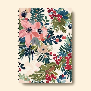 May include: A spiral bound notebook with a floral design featuring pink flowers, green leaves, and red berries on a white background.